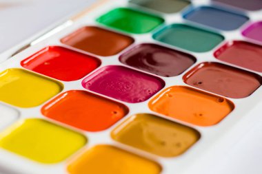 Bir masada çok renkli parlak suluboya boyalar yakın çekim