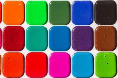 Çok renkli parlak suluboya boyalar yakın. Boyaların arka planı