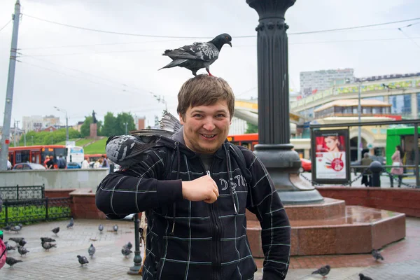 Die freche Taube drängte sich zu dem Kerl. Touristen bei Spaziergängen durch die Stadt — Stockfoto