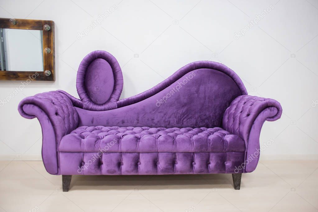 The violet velvet sofa costs in the light room with a mirror