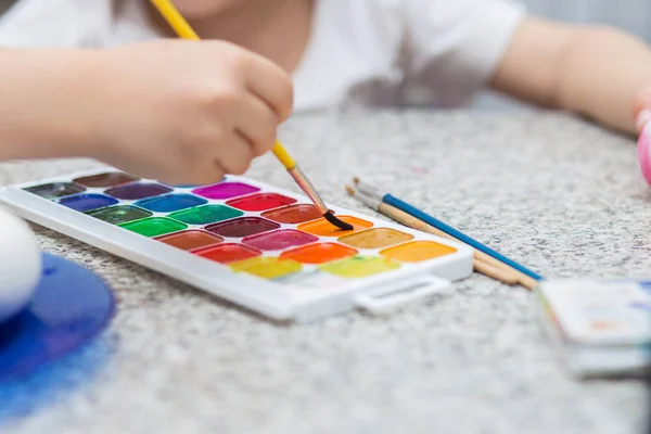 Акварель рисует курупный план. Детская рука с кистью рисует краски — стоковое фото
