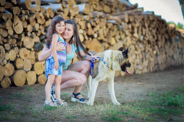 Madre con la hija pasear con el perro de la raza un Akita —  Fotos de Stock