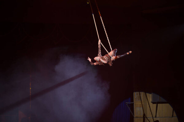 Volgograd, Russia, 09.26.2019: Girl aerialist performs in the circus arena. Acrobat on the ropes under the circus dome performs a dangerous number