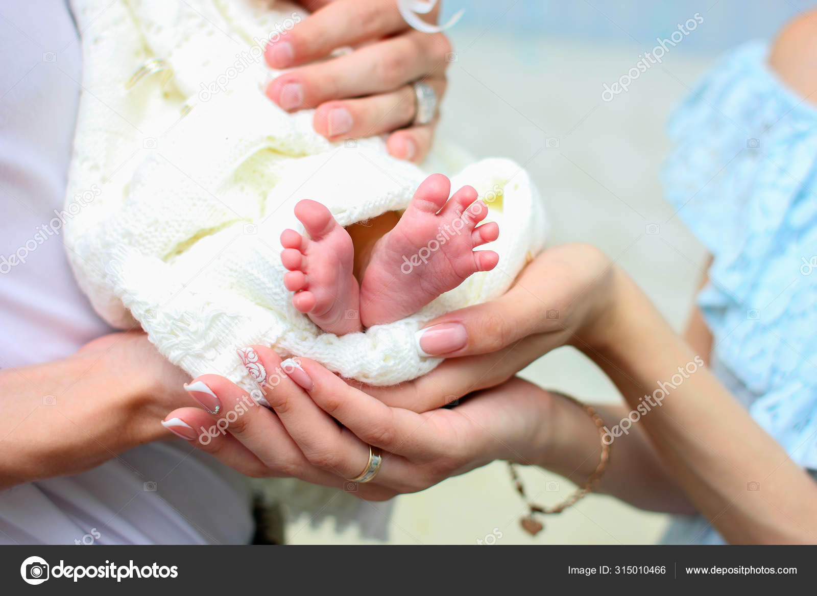 Las Manos De Mama Y Papa Sostienen Las Piernas Pequenas De Su Bebe Recien Nacido Envueltas En Una Manta Caliente Blanca Fotografia De Stock C Borisenkoket Depositphotos