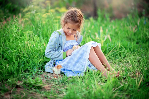 Klein Meisje Een Blauwe Zonnejurk Zit Het Gras Speelt Met — Stockfoto