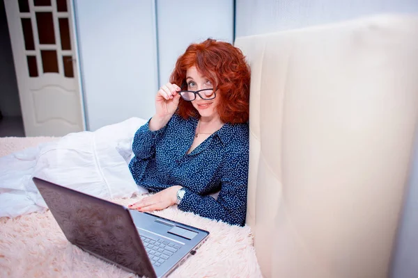 Cute Red Haired Girl Lies Bed Wearing Glasses Works Laptop — Stock Photo, Image