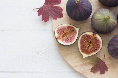 İncir ve sonbahar yaprakları üzerinde ahşap bir masa. Üstten görünüm