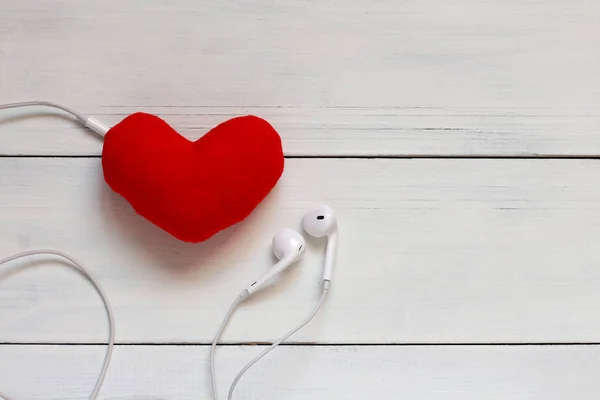 Corazón Rojo Felpa Auriculares Una Mesa Blanca — Foto de Stock