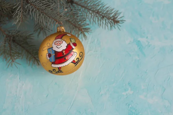 Goldene Weihnachtskugel Für Einen Tannenbaum Mit Weihnachtsmann Auf Blauem Hintergrund — Stockfoto