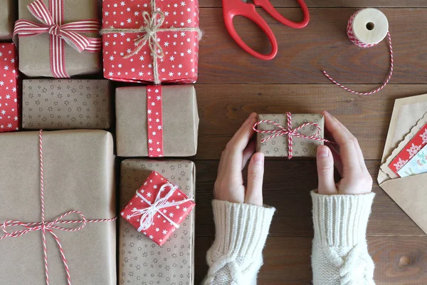 女性の手は 木製のテーブルでクリスマス プレゼントをパックします トップ ビュー — ストック写真