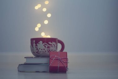 Christmas red mug on a pile of books.