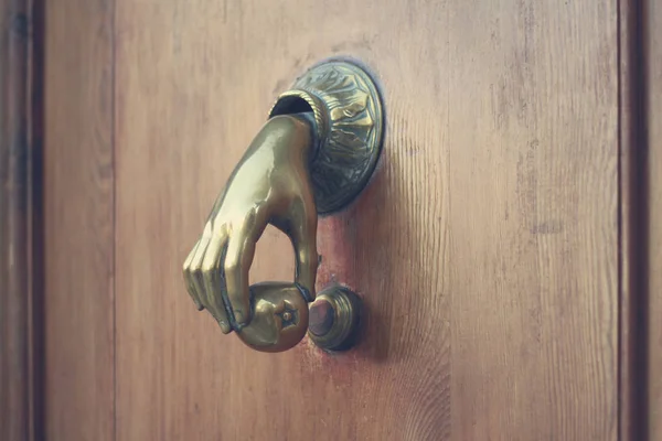 The vintage gong handle for knock at a door in the form of a hand with apple