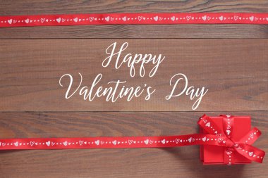 Mutlu sevgililer günü kartı. Ahşap masa üstü görünümünde kırmızı romantik hediye