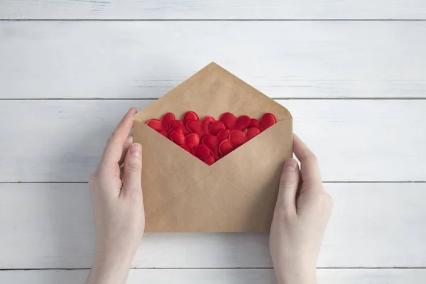 Les Mains Féminines Tiennent Une Enveloppe Avec Des Cœurs Rouges — Photo