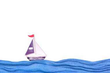 Kumaş dalgaları üzerinde oyuncak demir gemi. Yaz geçmişi