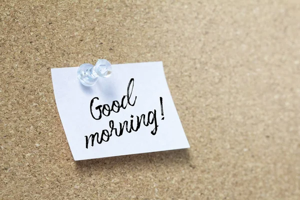 Good morning handwriting note on a wooden corkboard