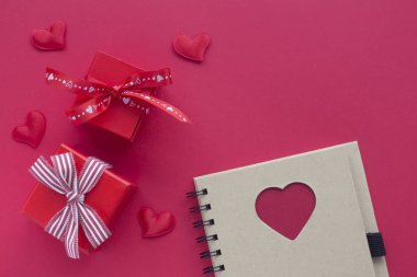 Kırmızı arka planda kalpleri ile kırmızı romantik hediye kutuları. Üst görüş kartı