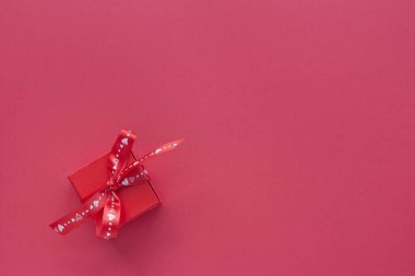 Pembe arka plan üst görünümünde kurdele ile kırmızı romantik hediye kutusu