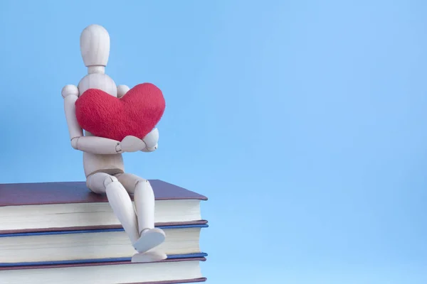 Wooden Puppet Human Siting Pile Books Red Plush Heart Hands — Stock Photo, Image