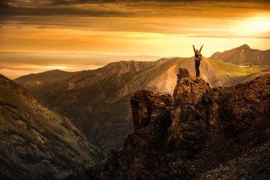 Genç kadın Backpacker zafer poz yukarı yükseltilmiş silah üstünde tepe-in dağ Colorado ABD ile yapılan