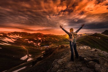 Genç kadın Backpacker zafer poz yukarı yükseltilmiş silah üstünde tepe-in dağ Colorado ABD ile yapılan