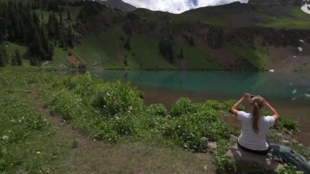 ハイカーは青い湖 リッジウェイのコロラド州で スマート フォンで写真を撮る — ストック動画