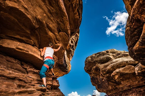 在峡谷地犹他州美国的一个美丽的红岩实践抱石的妇女登山者 — 图库照片