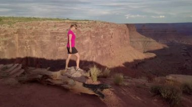 RIM, Doğu çatal Shafer Kanyon ölü at nokta State Park Canyonlands Utah Usa yakınındaki boyunca turist kız yürüyor 