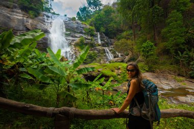 Sırt çantası ile genç yürüyüşçü kamera Wachirathon doğru gülümsüyor
