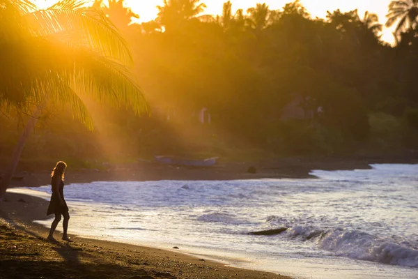 Mujer caminando por la playa al atardecer lado este de Bali Indone — Foto de Stock