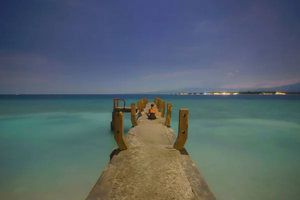 Genç kadın geceleri iskelede meditasyon uyguluyor. Gili Meno — Stok fotoğraf