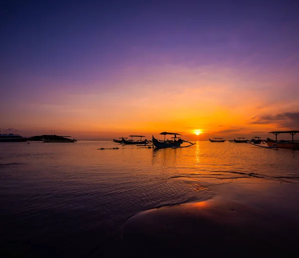 Embarcaciones tradicionales de pesca outrigger siluetas contra una puesta de sol —  Fotos de Stock