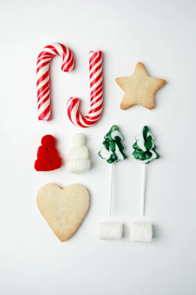 Christmas decorations and objects for mock up template design. Christmas candies, cookies, candy cane, decorative knitted hat. View from above. Flat lay. Xmas decorations. Christmas theme.