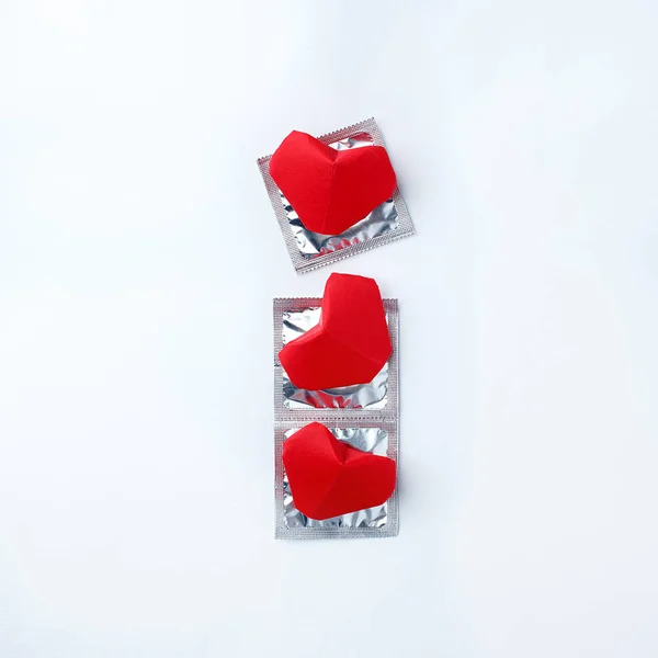 condoms and red hearts on white background. Love concept. Valentine\'s Day, romance event, sexual protection of health