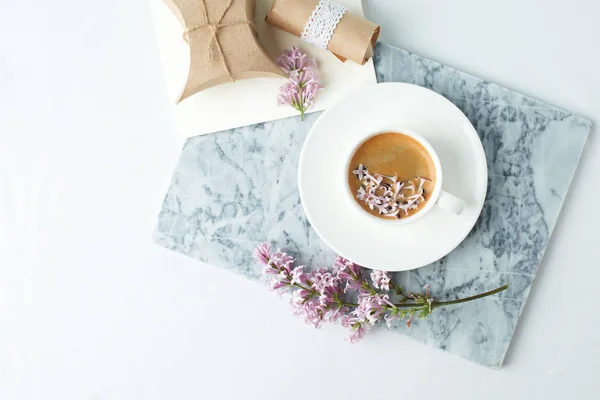 Minimalistic still life with coffee and lilac branches on marble