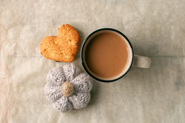 Tasty cocoa, cookies and knitted handcrafted pumpkin on the tabl