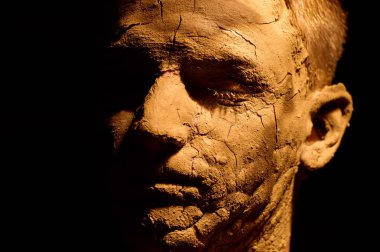 Yüz portre portre siyah arka plan üzerine. Kurutulmuş Kil yüzünde, kırık cilt. Yüzünde boş ekran.