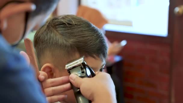 用剪刀和剃须刀给孩子理发 关闭的头发修剪发型由专业的发型师 — 图库视频影像