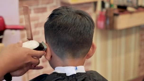 Master cuts a little boys hair in a barbershop — Stock Video © seregalsv  #562925534