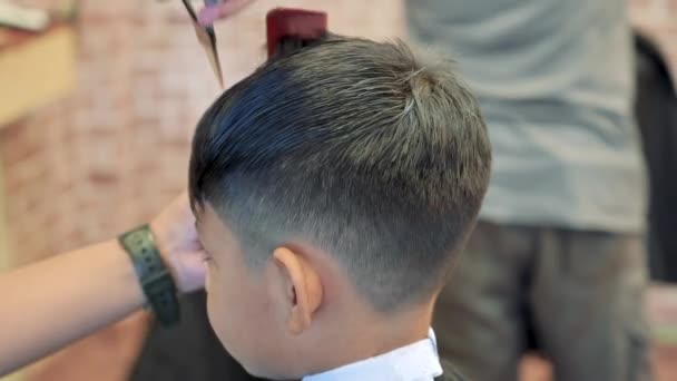 Kid haircut with scissors and razor. Close up of hair trimmer hairstyle by professional hair stylist. — Stock Footage Kid Haircut Scissors Razor Close Hair Trimmer Hairstyle Professional Hair Stock Video