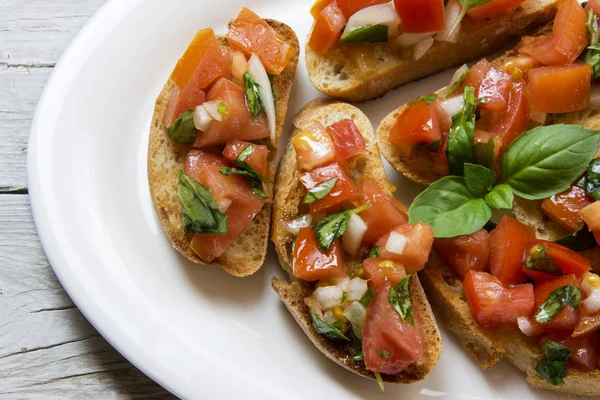 Bruscheta, Antipasti typisch italienisch mit Tomaten, Basilikum und Toas — Stockfoto