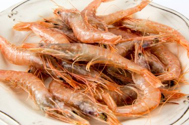 Tabakta birkaç çiğ karides var.