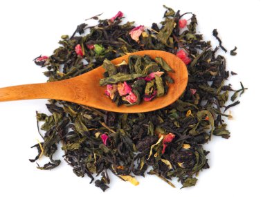 Yeşil ve siyah çay beyaz izole üzerine bir tahta kaşık, kurutulmuş.