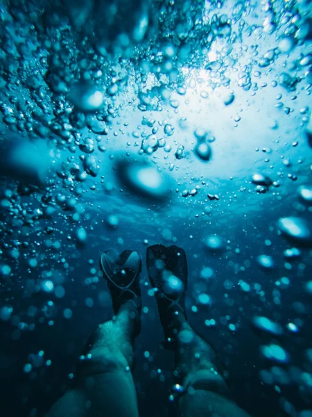 underwater shot of male feet in diving flippers