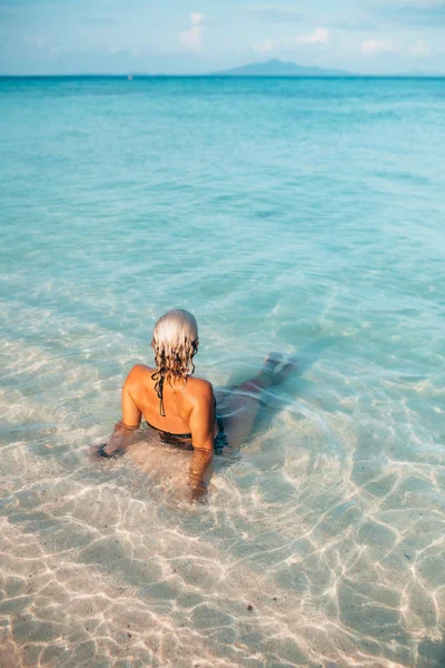 Visão Traseira Jovem Mulher Sentada Água Cristalina Praia — Fotografia de Stock