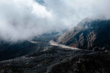 alçak bulutlu, dağlık manzaralı bir manzara. 