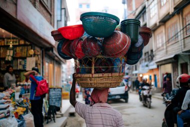 adam başında birçok sepet ile sokakta yürüyüş