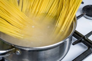 Spagetti bir gaz sobası üzerinde kaynar suda pişirilir. Geleneksel İtalyan yemekleri.
