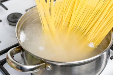Spagetti bir gaz sobası üzerinde kaynar suda pişirilir. Geleneksel İtalyan yemekleri.