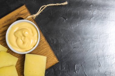 Siyah bir zemin üzerine peynir sos. Metniniz için yer.